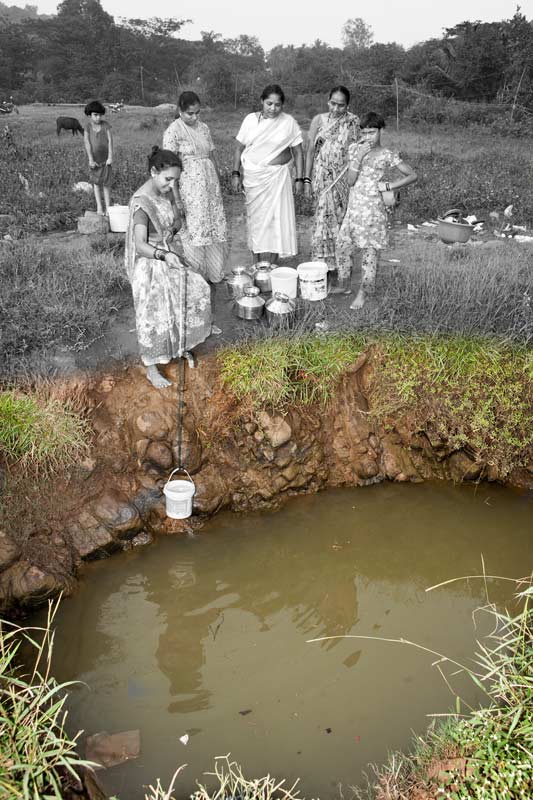 Urban Drinking Water Challenges - Collecting drinking water from an open well in Mumbai, Maharashtra
